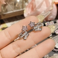 Macro detail of silver star stud earrings with pave zircon tassels held by a hand - 0185 White Gold Comet Meteor Ear Clips