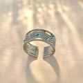 Detalle de anillo multicapa plateado con piedras azules y motivos de estrellas - Abierto Ajustable / Acero Inoxidable Color Plata Zirconia Azul