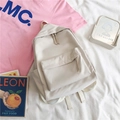 Flat lay of cream minimalist nylon backpack for students with leon book and cute props - Off-white