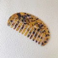 Dettaglio del pettine in acetato tartarugato a denti larghi su uno sfondo testurizzato - Piccolo a denti larghi / Giallo
