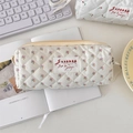 Gros plan d'une trousse de maquillage matelassée à fleurs roses et fermeture éclair - Petit / Fleur Beige