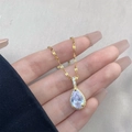 Detalle de collar de gota con gema pera y cadena dorada texturizada de estilo vintage - Dorado