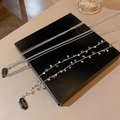 Detail of silver hair chain with sparkling star pendants and rhinestones on a black box - Chain Style + Star Style