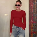 Close-up detail of the side ruching and slim fit fabric on a red long sleeve top - S / Red