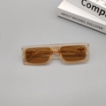 Detail view of retro square sunglasses featuring amber frames and stylish brown lenses - Champagne