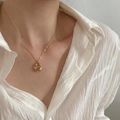 Minimalistische Goldkette mit unregelmäßigem ovalem Anhänger am Hals getragen - Unregelmäßiger Anhänger-Stil