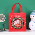 Red Christmas non-woven gift bag with Santa Claus wreath design and sturdy handles - Flower Garland