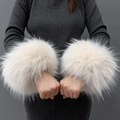 Close-up of soft white faux fur wrist cuffs shown on a model with a grey background - Apricot Jacquard