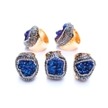 Close-up of five bohemian golden hammered rings featuring irregular blue druzy crystals - Blue Lustre