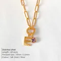 Elegante collana in acciaio inossidabile dorato con ciondolo lettera E e gemma viola - Lettera E (XNL0079)