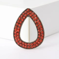 Macro detail of teardrop brooch with red coral beads and vintage gold alloy setting - Red