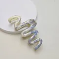 Detail of S-shaped hair claw clip with blue marble ink pattern on a minimalist stand - 13cm Snake Wave / Blue White Floral