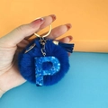 Detail of blue pompom keychain with sequined letter P and matching blue tassel charm - Letter P