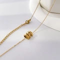 Macro view of gold triple ring pendant necklace with adjustable chain and lobster clasp - Triple Rings