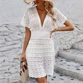 Detail of white crochet beach dress featuring V-neckline and hollow geometric lace texture - White