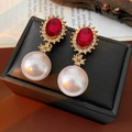 Detail of vintage gold earrings with red gems, pavé diamonds, and large pearls on a box - Ruby Pearl Cross Drop Earrings (Silver Pin) / Red-White-Gold