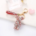 Close-up of a sparkling rhinestone bear keychain with red glitter hand strap for bag decor - Mixed Red