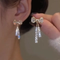 Sparkling crystal bow tassel earrings with gold-tone finish on a female model - Gold Bowknot Rhinestone Tassel