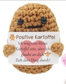 Detailed view of handmade crochet positive potato doll with motivational German card - Dark Brown Potato With German Card