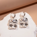 Dettaglio di orecchini quadrati argentati con design a onde irregolari e lucentezza metallica - Quadrato Piegazzato (Perno in Argento - Argento)