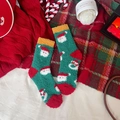 Green coral fleece Christmas socks featuring white Santa Claus pattern and warm plush texture - Snowman Santa Claus