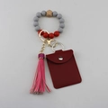 Close-up of silicone bead wristlet with pink tassel and red faux leather card holder - Red