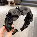 Detalle de diadema de tela negra plisada con elegantes adornos de lazos en cuentas negras - Lazo de Diamantes de Imitación Fruncido Negro