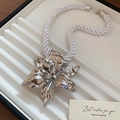 Dettaglio della collana con ciondolo a fiore d'argento e cordino bianco in scatola regalo - Collana con fiori 3D argento (corda intrecciata bianca)