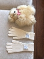 Detalle de guantes táctiles de lana tejida beige con etiquetas sobre una tela suave - 26x10cm / Marfil