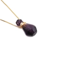 Macro shot of faceted purple stone perfume bottle pendant with golden necklace - 1NSN0233-2 Amethyst