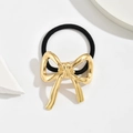 Minimalist gold alloy bowknot hair tie with elastic black band on a white stone background - Ribbon Bow Gold