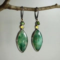 Pendientes vintage con gemas verde oliva en forma de gota sobre rama de madera natural - Verde Esmeralda