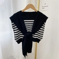 Châle en tricot à rayures noires et blanches présenté sur un cintre en bois - Motif à Rayures