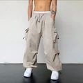 Détail du pantalon cargo beige clair avec taille à cordon et grandes poches latérales - Abricot