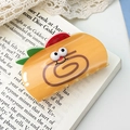 Yellow swiss roll hair claw with strawberry and smiley face on an open book - Strawberry Roll