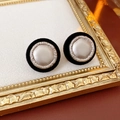 Dettaglio di orecchini vintage con floccaggio nero, perla e bordo in argento intrecciato - Nero-Argento