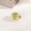 Macro view of gold spacer bead with pink and blue enamel stripes and green zircon stones - Pink & Blue