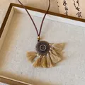 Vue détaillée d'un pendentif en bronze vintage avec d'élégants glands en coton beige - Style Gland Rond Café Clair