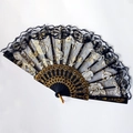 Detail of black lace folding fan featuring gold rose embroidery and ornate carved ribs - Black