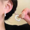 Detail of silver C-shaped hoop earrings featuring sparkling pave set stones on a model - Micro-Pave Zirconia Icy C-Hoop / Silver
