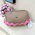 Detail of taupe pebbled leather camera bag with pink wavy strap and gold metal logo - Khaki (Rose Strap)