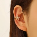 Floral ear cuff in gold finish with white zircon crystals shown on ear lobe - Gold Flower Style (A-1153)