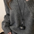 Close-up of minimalist black leather mini pouch with gold snap button on grey knit sweater - 23# Necklace - Black - Mini Leather Bag Pendant