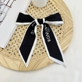 Black and white bow hair ribbon with ROMANT PARIS lettering on woven tray - Black Blind for Love