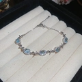 Bracciale in argento con gemme blu ovali e fiocchi su vassoio per gioielli - Stile con Fiocco e Cinque Pietre Preziose