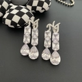 Boucles d'oreilles pendantes argentées avec zircons carrés et en poire sur fond cuir noir - Clous d'Oreilles Goutte d'Eau en Zircon Artisanat Lourd