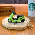 Vibrant green miniature motor scooter keychain toy displayed on a wooden base - Electric Vehicle Keychain - Green