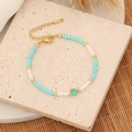 Detailed close-up of beaded bracelet with turquoise heart charm and golden lobster clasp - Green/1# Transparent Green