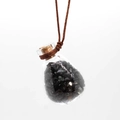 Detail of clear glass perfume bottle pendant filled with black crushed crystal stones - Black Agate