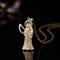 Pendentif Santa Muerte doré avec zircons colorés sur une surface noire réfléchissante - Faucheuse 01 Zirconium Coloré